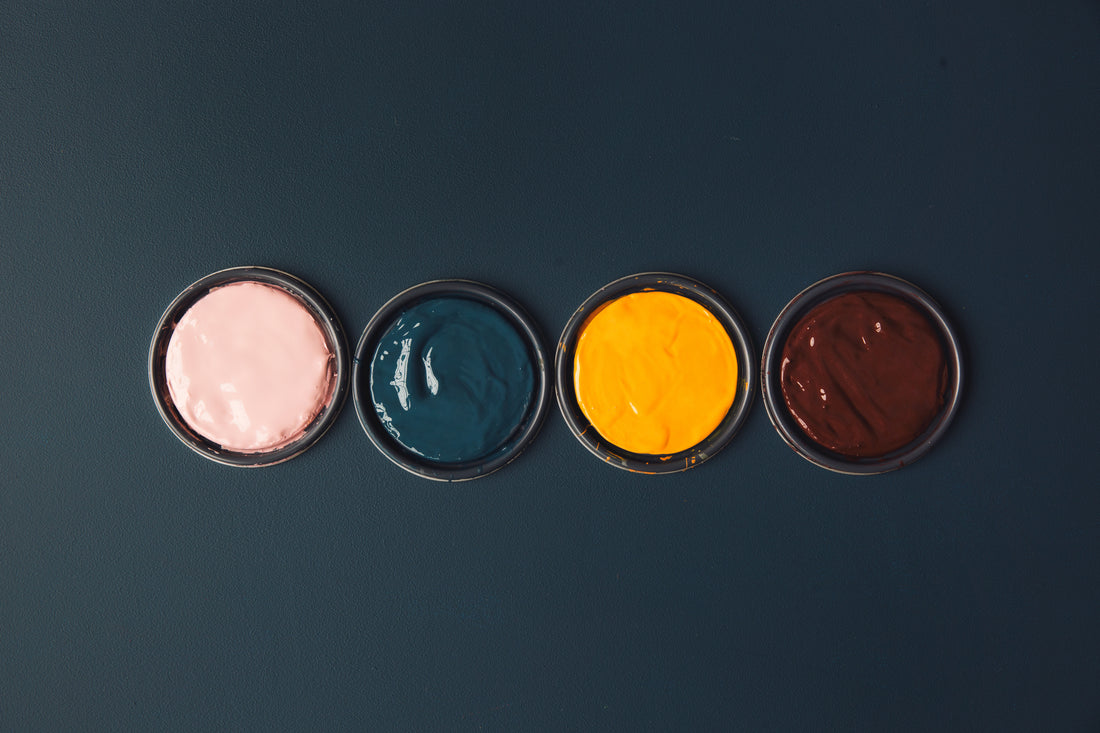 Pots of bright paint on a blue table